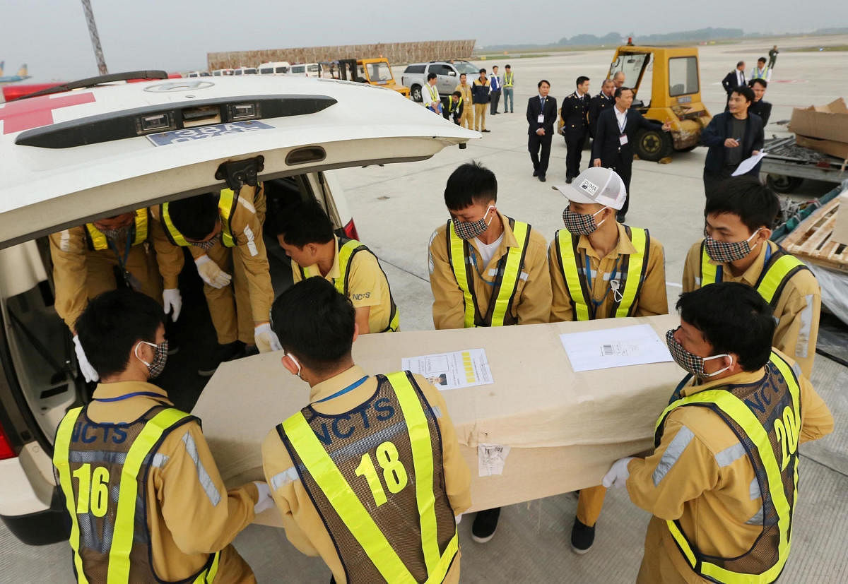 Airport workers move a coffin, carrying one of the 39 bodies found on a truck container in Britain, to an ambulance for homeland repatriation at Noi Bai airport in Hanoi. (Reuters photo)