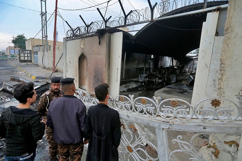Security force and civilians gather near the burned Iranian consulate in Najaf, Iraq. (PTI Photo)