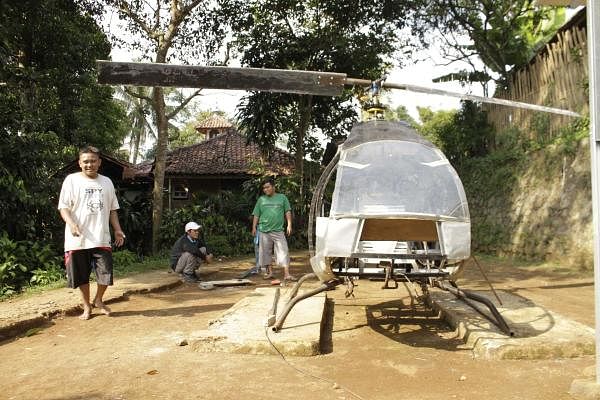 his picture taken on November 17, 2019 shows Jujun Junaedi (L) working on his homemade helicopter in his backyard in Sukabumi. (AFP photo)