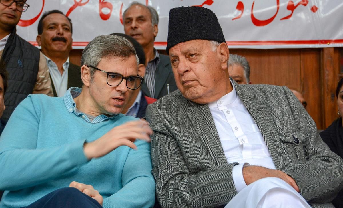 National Conference President Farooq Abdullah with his son, party Vice-President Omar Abdullah during a convention ahead of Lok Sabha elections, at party headquarters, in Srinagar, Saturday, March 30, 2019. (PTI Photo)