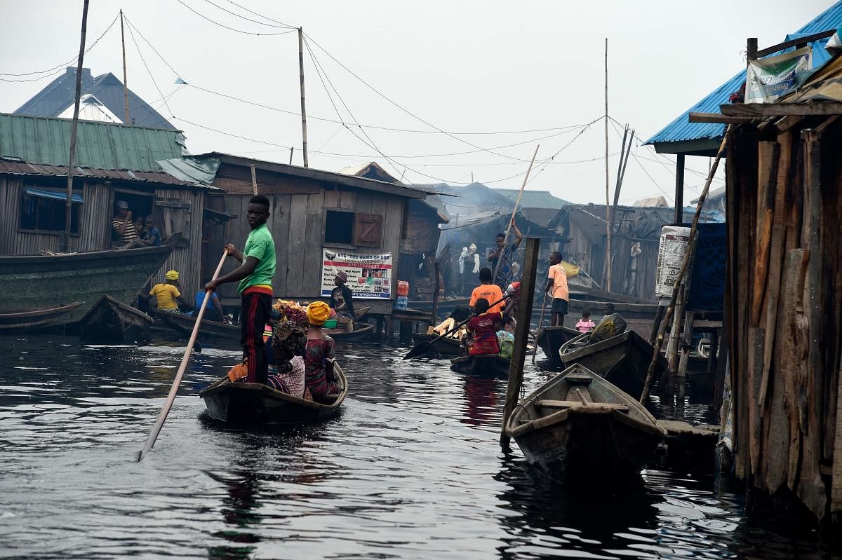 A boy stands on a canoe as part of his daily routine in the Makoko waterfront settlement in Lagos, on October 23, 2019. - Code for Africa, an aid group that is using drones and young slum dwellers to map Makoko at the heart of Nigeria's economic capital. (AFP Photo)