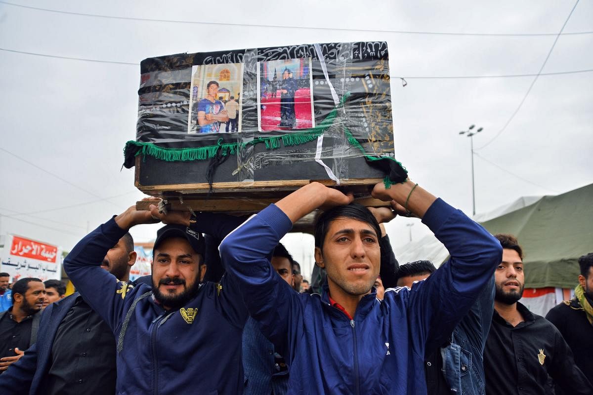 Young Iraqis carry a coffin of an anti-government demonstrator killed during protests a day earlier, during a funeral procession in the central holy shrine city of Najaf. Nearly 45 people were reportedly killed and hundreds wounded across Iraq yesterday,