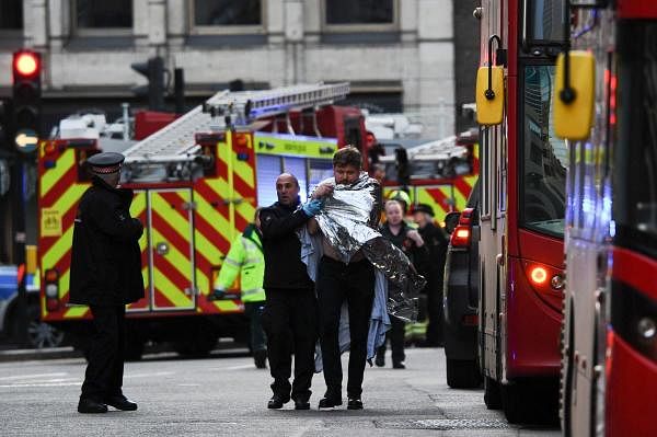 Police assist an injured man near London Bridge in London, on November 29, 2019 after reports of shots being fired on London Bridge. (AFP photo)
