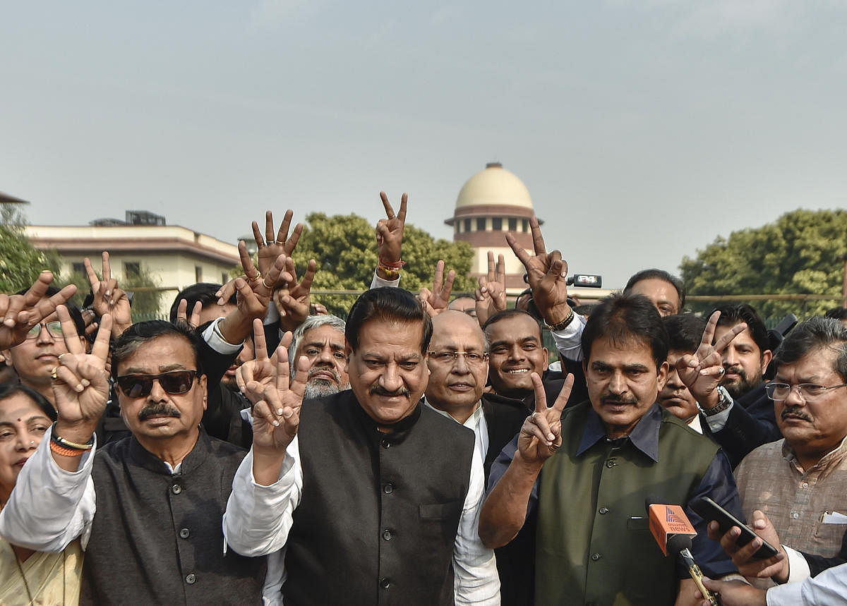 Senior Congress leaders Prithviraj Chavan, Abhishek Singhvi, KC Venugopal, Shiv Sena MP Gajanan Kirtikar and others display victory sign at the Supreme Court of India during a media interaction, in New Delhi, Tuesday, Nov. 26, 2019. (PTI Photo)