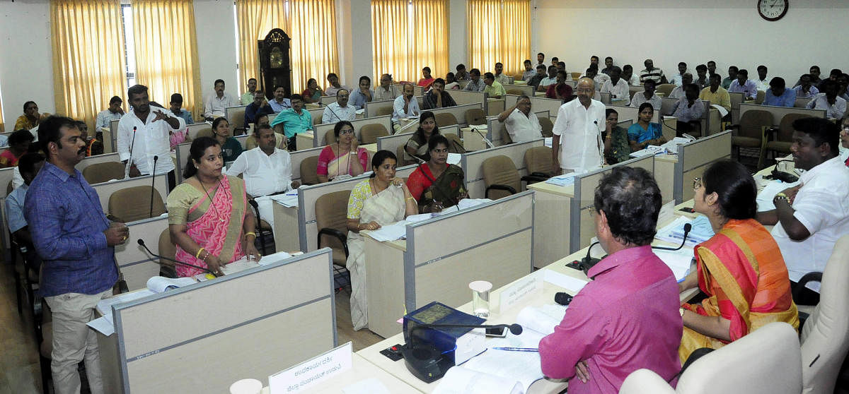 Members raise a point at the Zilla Panchayat meeting which was presided by the president of the zilla panchayat, Dinakar Babu, at the Zilla Panchayat Hall in Manipal.