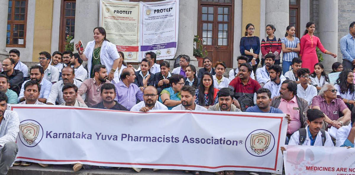 Pharmacists and students from various colleges in the city staged a protest at Town Hall on Friday. DH photo
