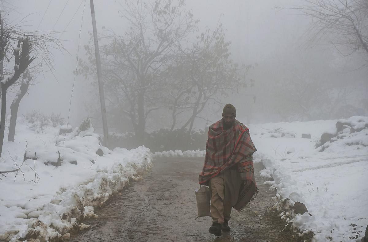 A pedestrian walks amidst fog following light snowfall, on the outskirts of Srinagar, Thursday, Nov. 28, 2019. (PTI Photo)