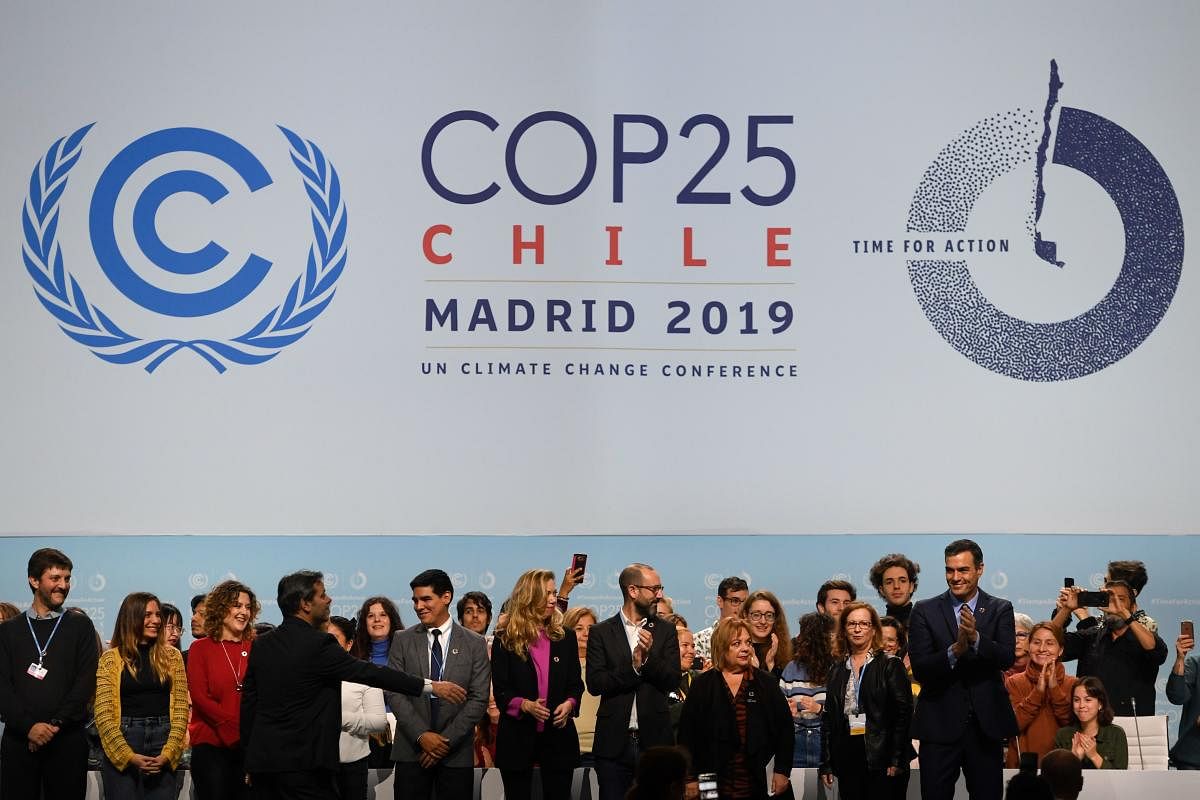 Spanish Prime Minister Pedro Sanchez (R) applauds as he poses with volunteers onstage during a visit to the congress centre IFEMA in Madrid on November 30, 2019 where the COP25 climate summit will be held from December 2 to 13, 2019. (AFP Photo)