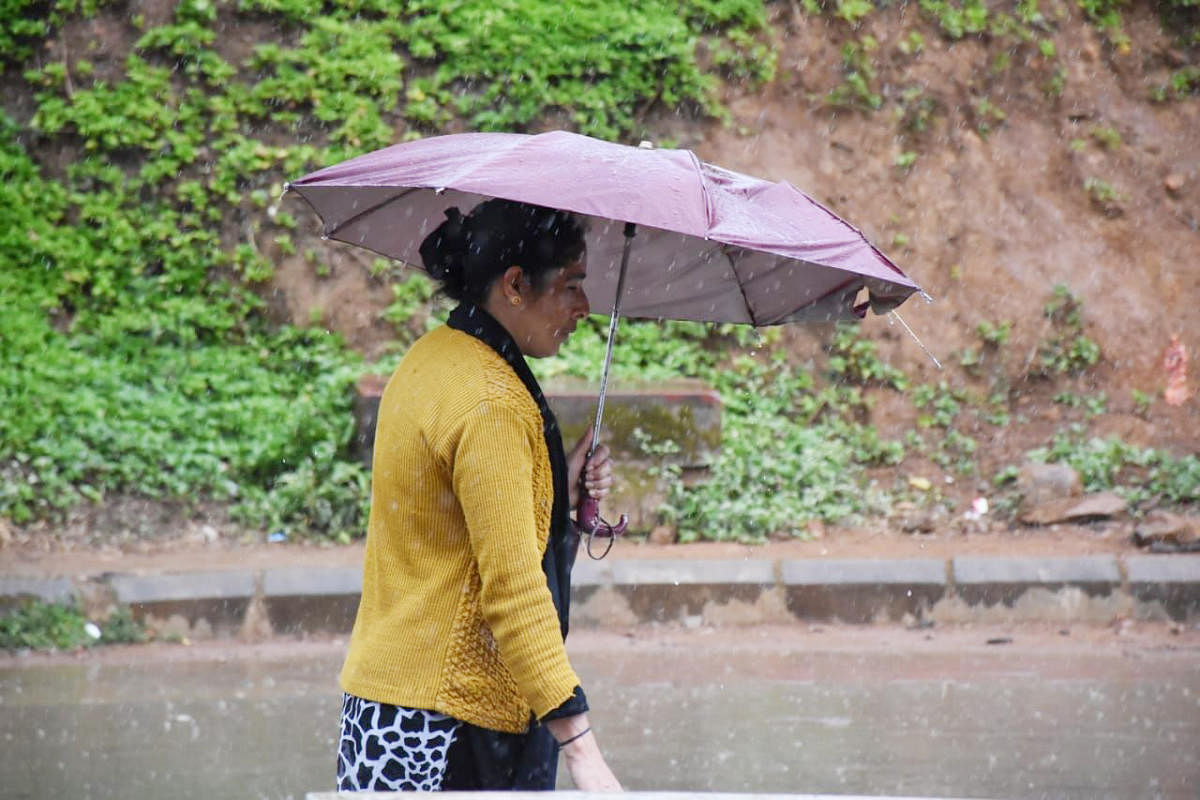 A lady walks on the road during the rain in Madikeri on Sunday afternoon.