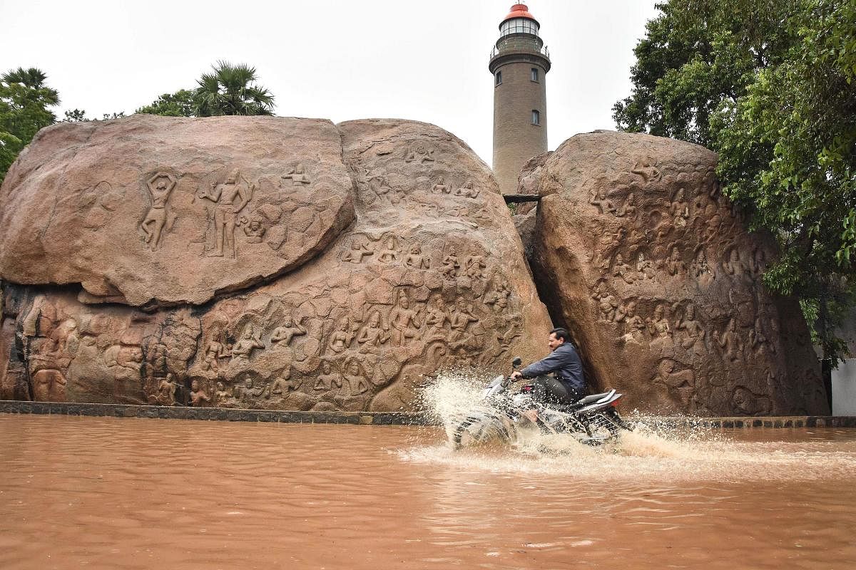  A man rides a motorcycle through a waterlogged road after heavy rains, at the heritage site of Mamallapuram. PTI
