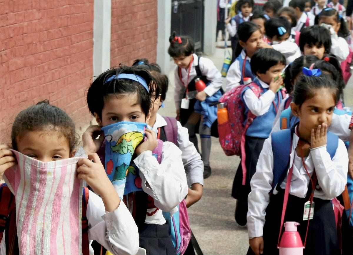 School children cover their noses as air pollution reached hazardous levels in New Delhi. PTI photo