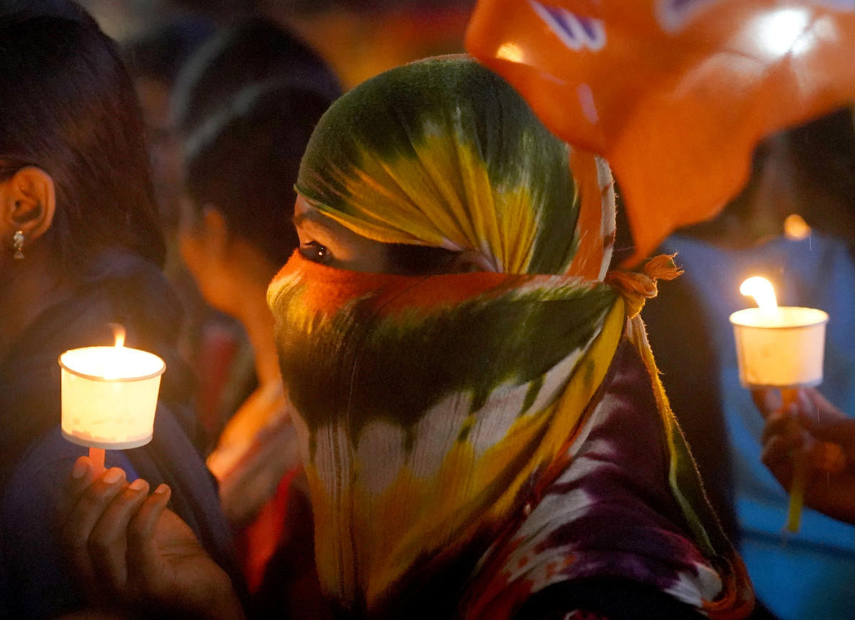 A woman holds a candle during a vigil as she attends a protest against the alleged rape and murder of a 27-year-old woman in Hyderabad. (Reuters photo)