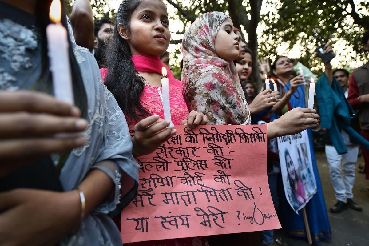 Girls along with activists take part in a candle light protest over the Hyderabad rape and murder case, in New Delhi (PTI photo)