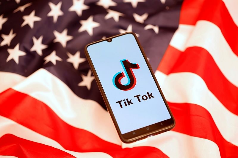 TikTok logo is displayed on the smartphone while standing on the US flag in this illustration picture taken. (Reuters Photo)