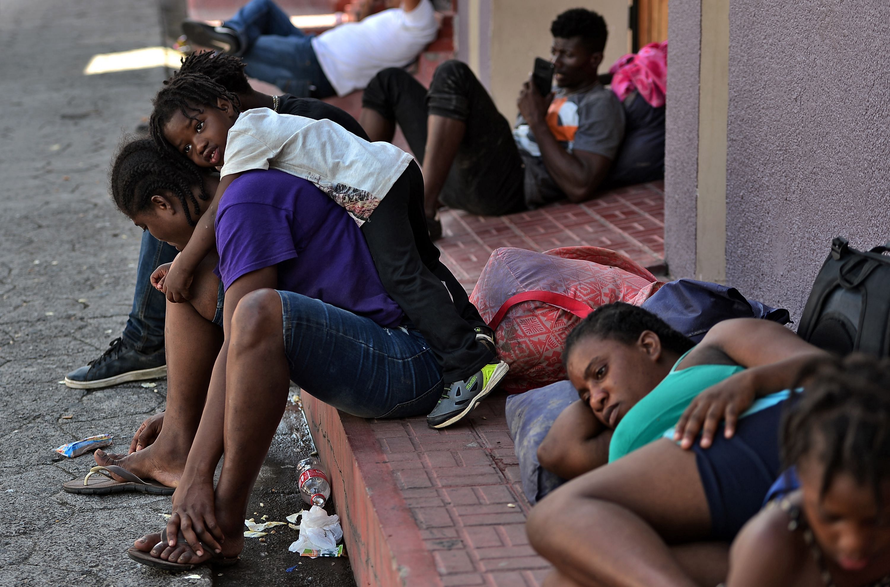 African and Haitian migrants wait outside the migrations office in Choluteca, Honduras. (AFP Photo)