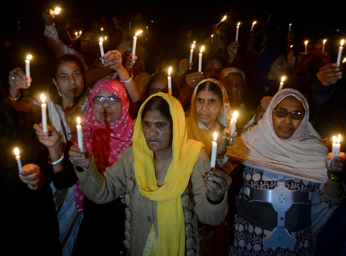Women hold candles during a vigil to mark the 35th anniversary of the Bhopal gas disaster, in Bhopal. (Reuters photo)