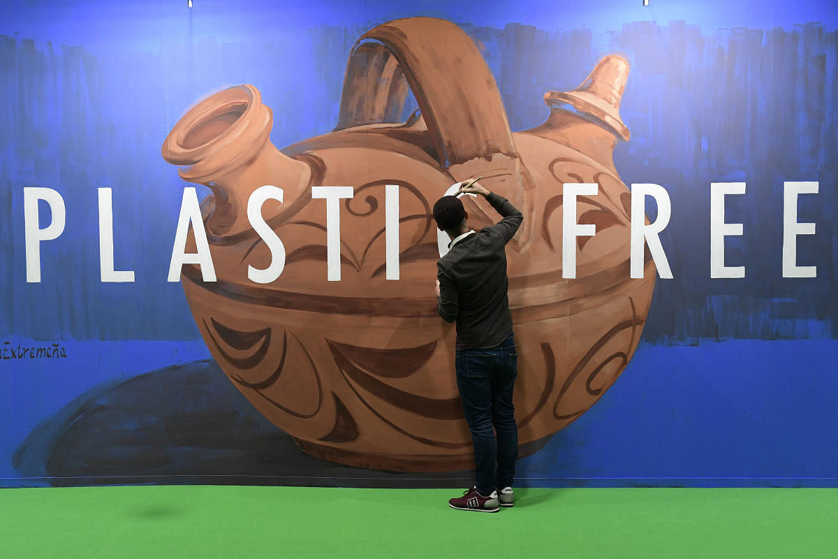 panish street artist Jonatan Carranza aka Sojo paints a mural depicting an Extremaduran typical earthenware pitcher during the UN Climate Change Conference COP25 at the 'IFEMA - Feria de Madrid' exhibition centre, in Madrid, on December 3, 2019. (Photo by AFP)