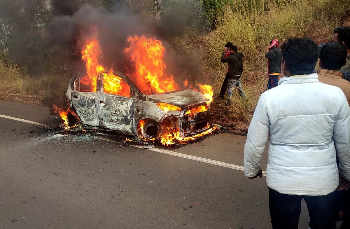 The Hyderabad-bound SUV catches fire at Nirna Cross in Chitguppa taluk, Bidar district, on Thursday. A woman wearing seat belt was burnt alive while her husband and their two sons escaped unhurt in the incident.