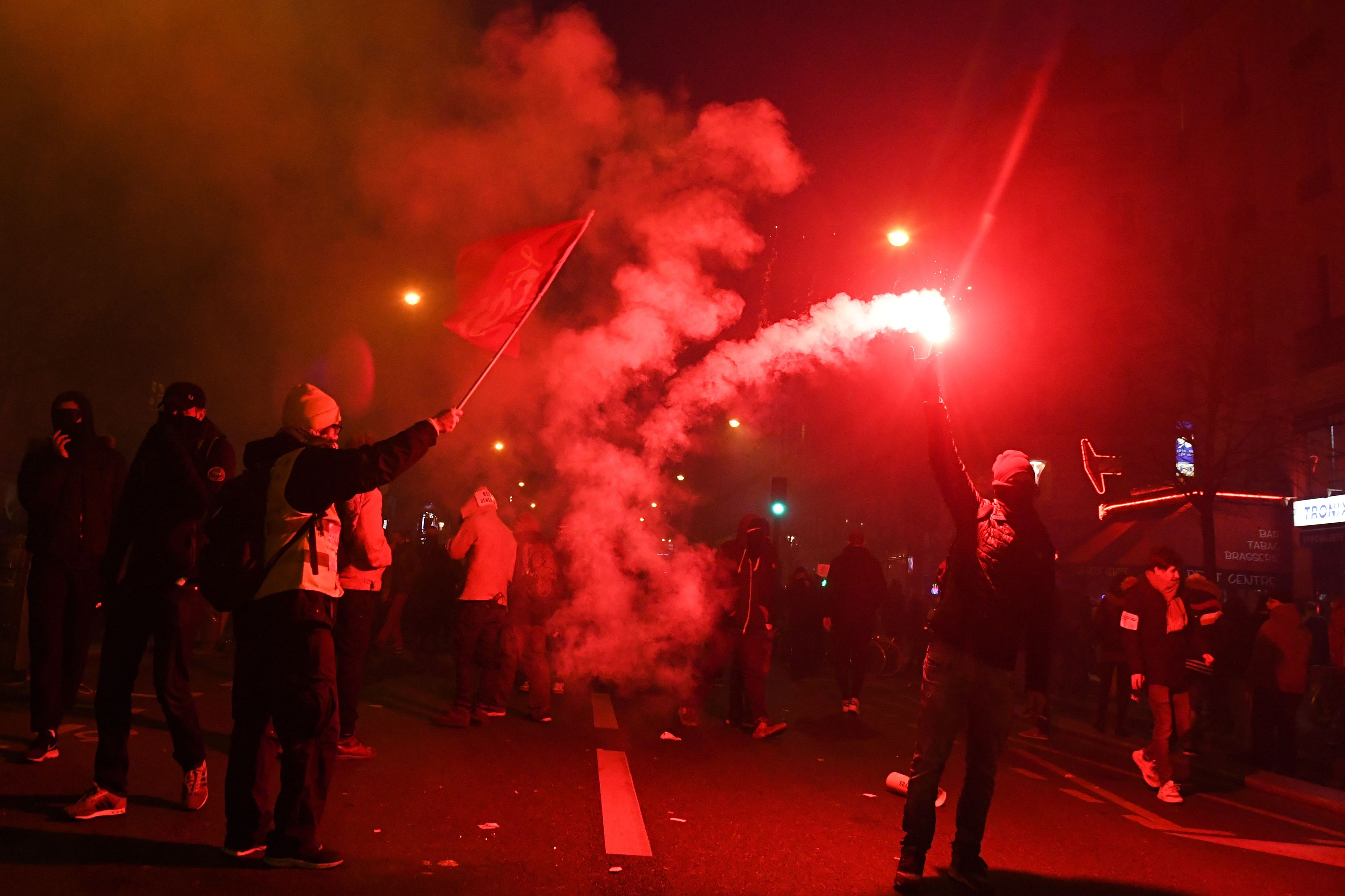A protester brandishes a red flare during a demonstration against the pension overhauls, in Paris. (AFP Photo)