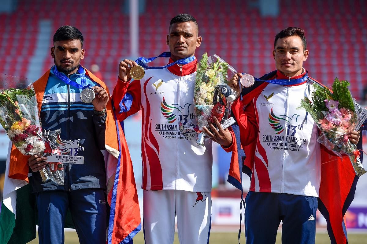 ilver medallist India's Sunil Dawar (L), gold medallist Nepal's Gopi Chand Parki (C) and bronze medallist Nepal's Hari Kumar Rimal (R) pose with their medals of the men's 5000-meter race at the 13th South Asian Games (SAG) in Kathmandu on December 6, 2019. (Photo by PRAKASH MATHEMA / AFP)