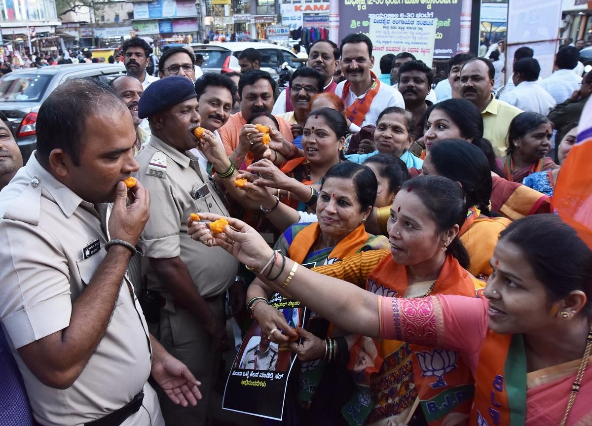 BJP's women wing members celebrate the encounter of four accused in Hyderabad rape case by offering sweets to police at Durgadbail Circle in Hubballi on Saturday. DH photo / Tajuddin Azad