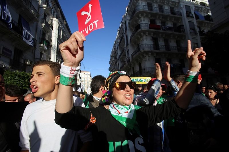 A demonstrator holds a sign reading "No vote" as she takes part in a protest to demand for the presidential election scheduled for next week to be cancelled, in Algiers, Algeria. (Reuters Photo)