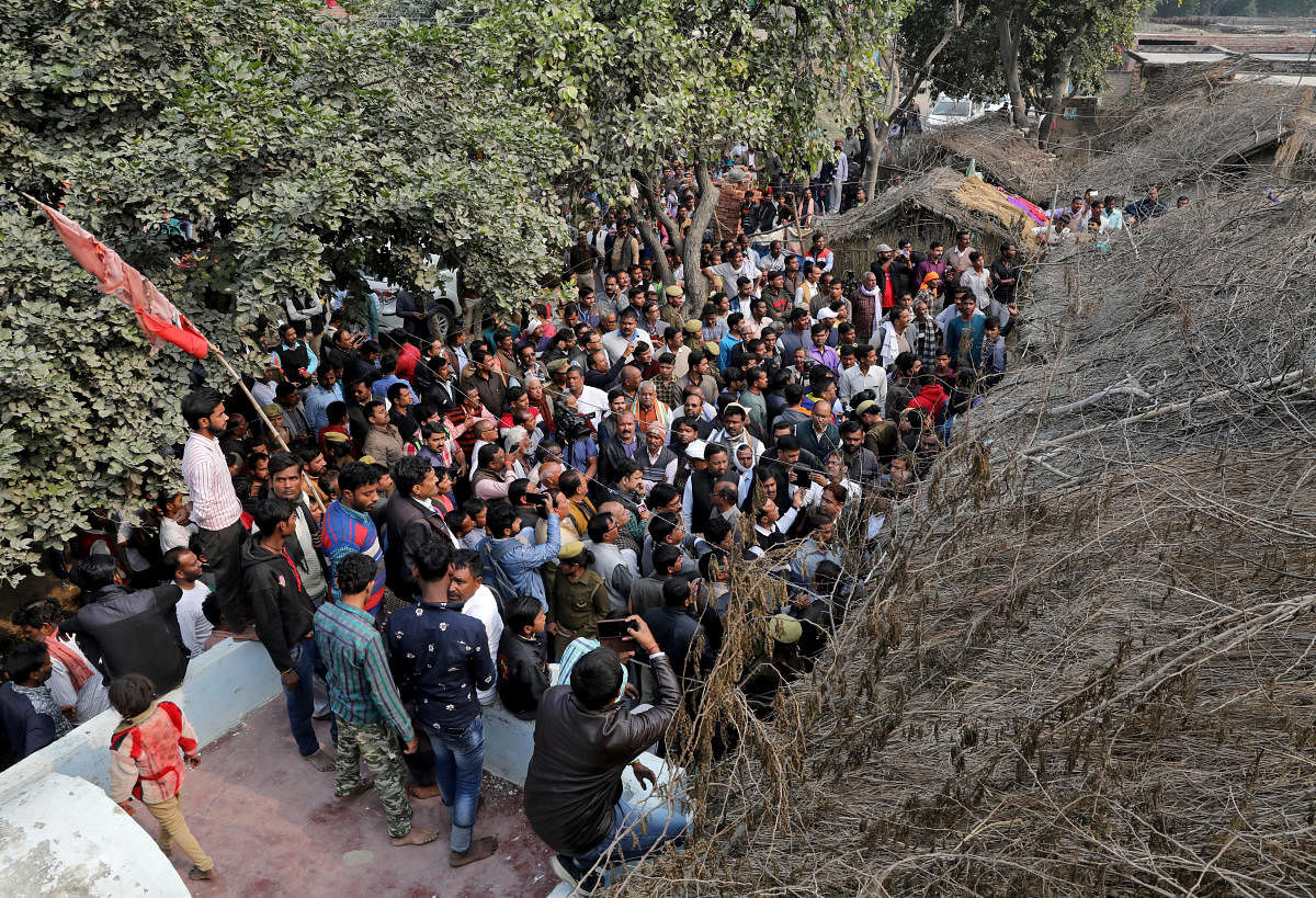 People gather outside the house of a 23-year-old rape victim, who died in a New Delhi hospital on Friday after she was set on fire by a gang of men, which included her alleged rapists, in Unnao. Reuters