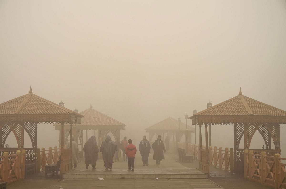 Srinagar: Pedestrians cross a bridge over river Jehlum on a cold, foggy morning (PTI Photo)