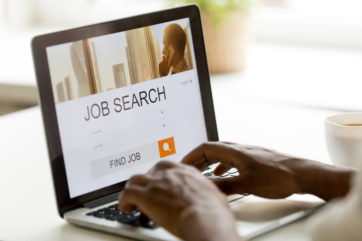 A man browsing work opportunities online using job search computer.