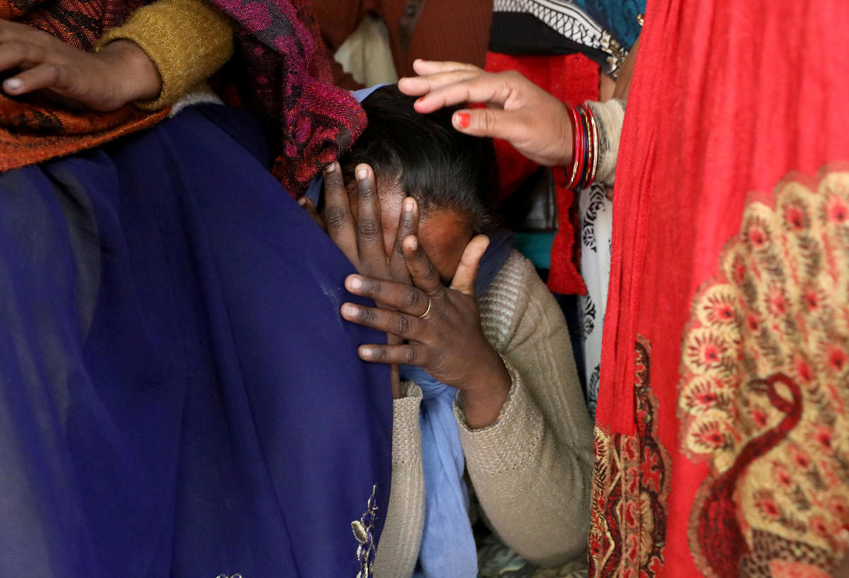 A relative of a 23-year-old rape victim, who died in a New Delhi hospital on Friday after she was set on fire by a gang of men, which included her alleged rapists, is consoled as she mourns the death of the victim outside a house in Unnao. (Photo by Reuters)