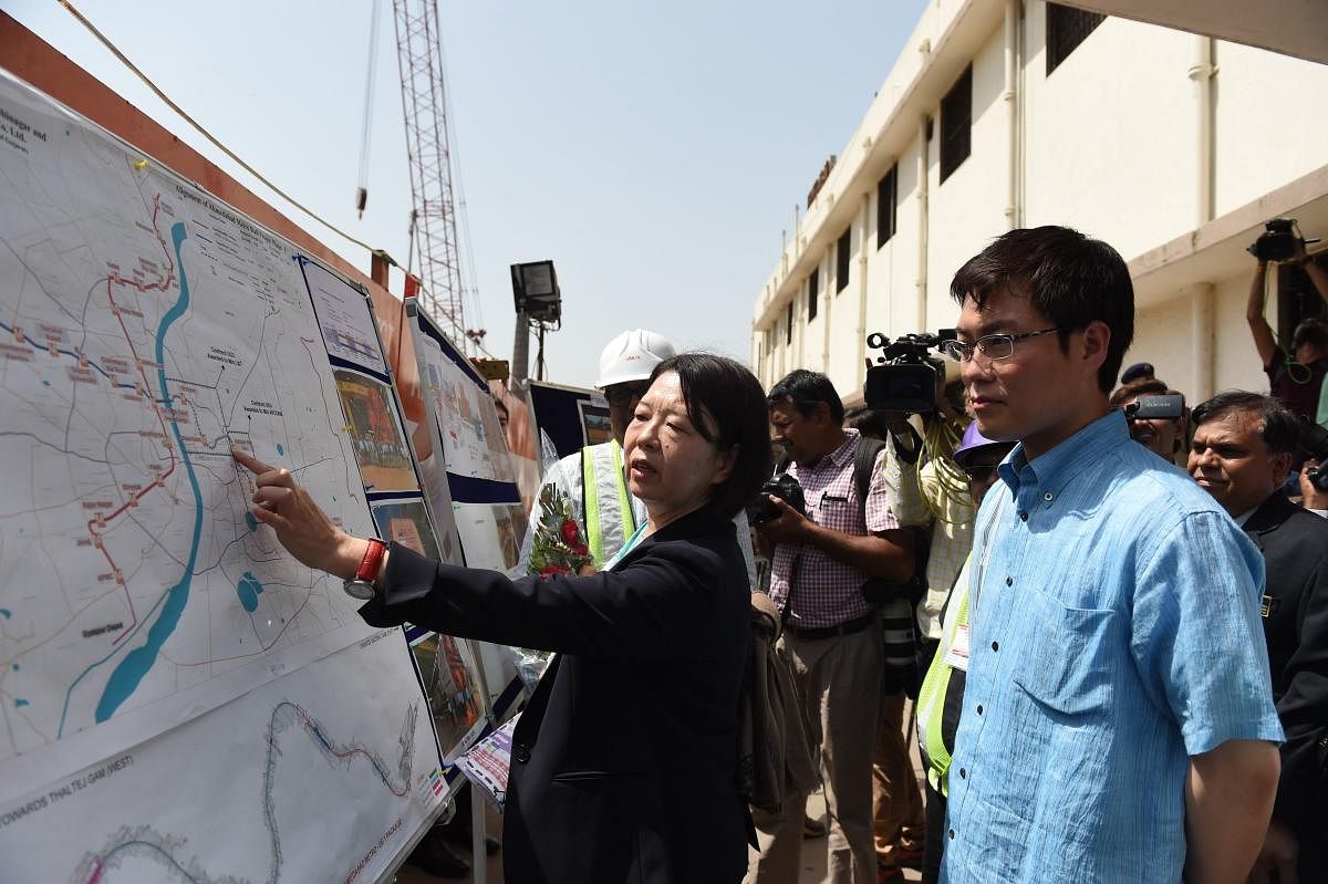 Japanese parliamentary vice-minister of land, infrastructure, transport and tourism, Masatoshi Akimoto (R) looks at a map of Ahmedabad Metro Rail during his visit at Kalupur Railway Station in Ahmedabad. (AFP Photo)