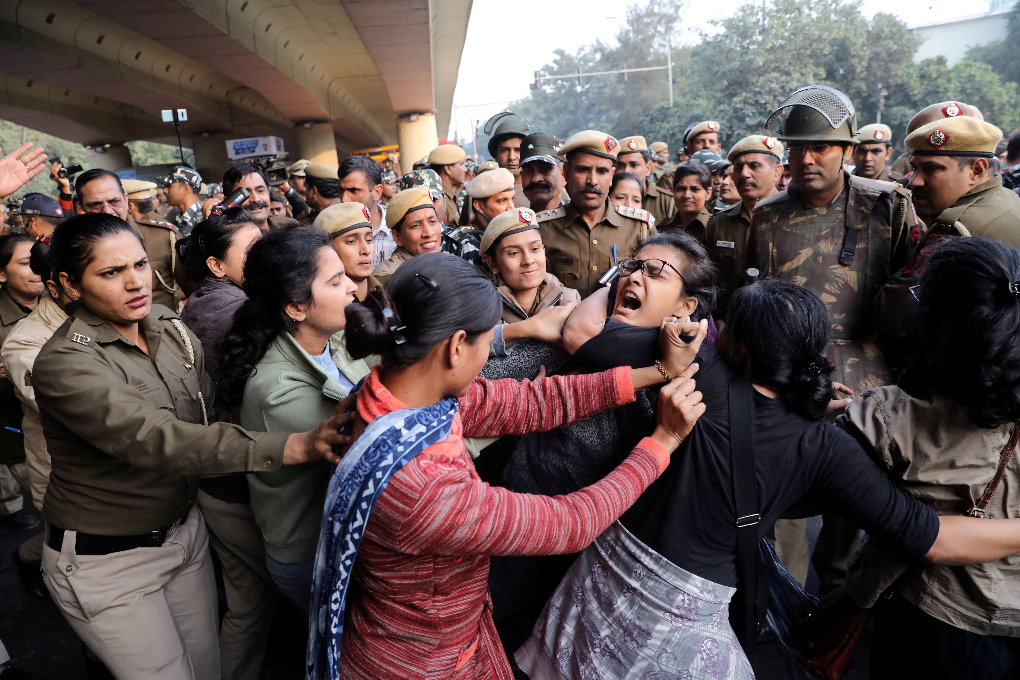 Police officers try to detain a student of Jawaharlal Nehru University (JNU) during a march to Rashtrapati Bhavan to protest against a proposed fee hike, in New Delhi. (Reuters photo)