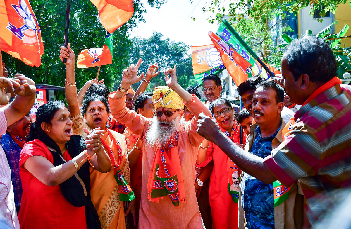 BJP workers celebrate after the party won 12 seats in the bypolls in Bengaluru on Monday. DH photo/Krishnakumar P S