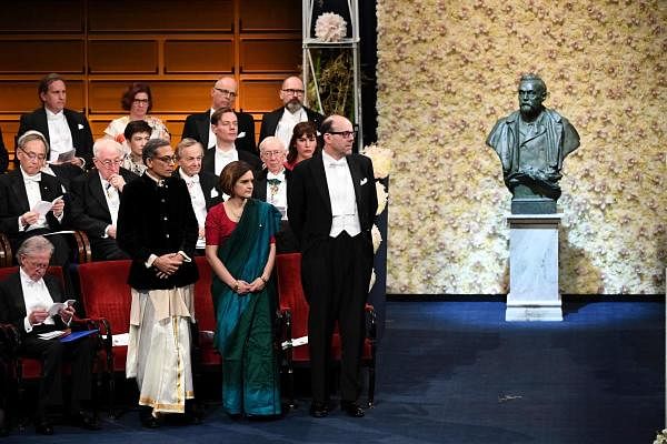 US development economist and co-laureate of the 2019 Nobel Prize in Economic Sciences Michael Kremer (R) stands next to colaureates French–American economist Esther Duflo (C) and US economist Abhijit Banerjee (L) during the Award ceremony on December 10, 2019 at the Concert Hall in Stockholm, Sweden. (AFP Photo)