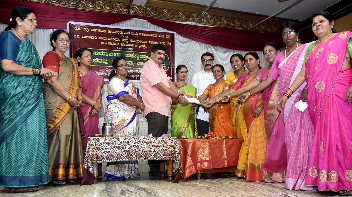 Anganwadi Workers and Assistants’ Association office-bearers submit a memorandum to Mangaluru South MLA D Vedavyas Kamath, during a conference held on the premises of the Kudroli Sri Gokarnanatha temple in Mangaluru on Thursday. 