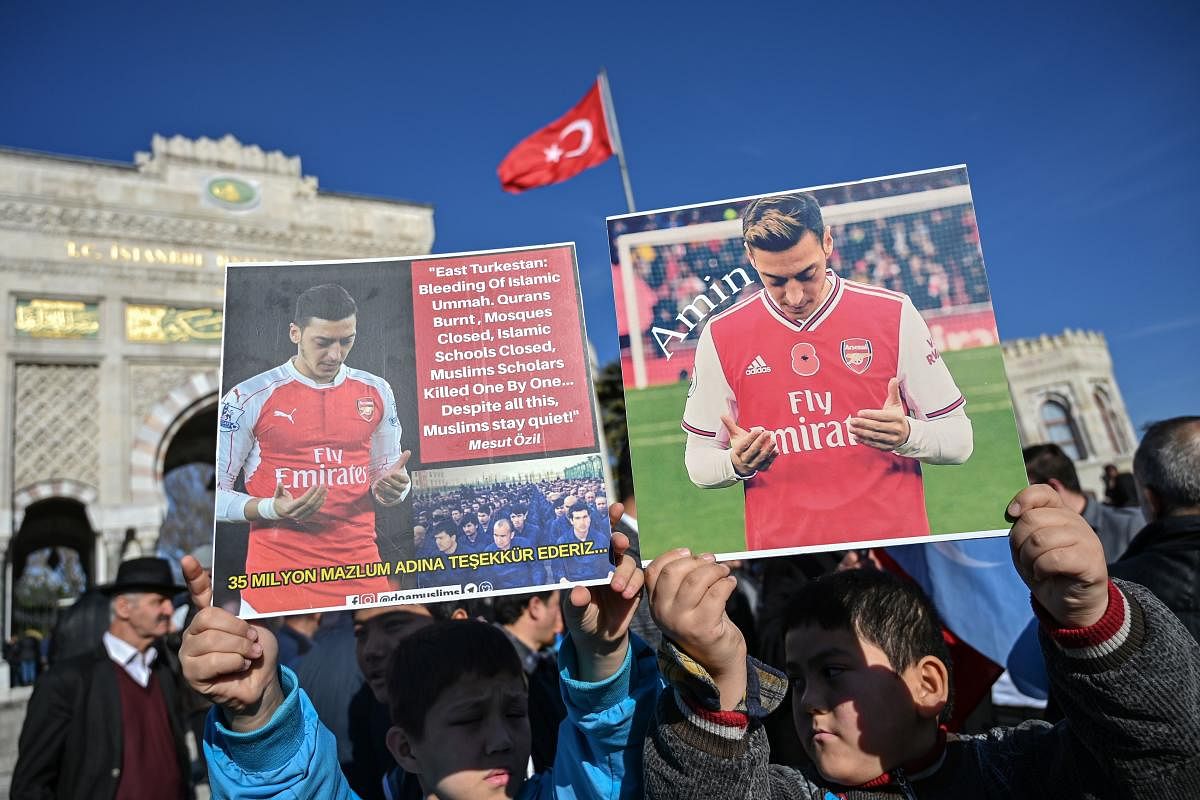 Supporters of China's Muslim Uighur minority hold placards of Arsenal's Turkish origin German midfielder Mesut Ozil during a demonstration at Beyazid square in Istanbul on December 14, 2019. - Arsenal's Mesut Ozil, a German footballer of Turkish origin, expressed on December 14, 2019 support for Uighurs in Xinjiang and criticised Muslim countries for their failure to speak up for them. (Photo/ AFP)