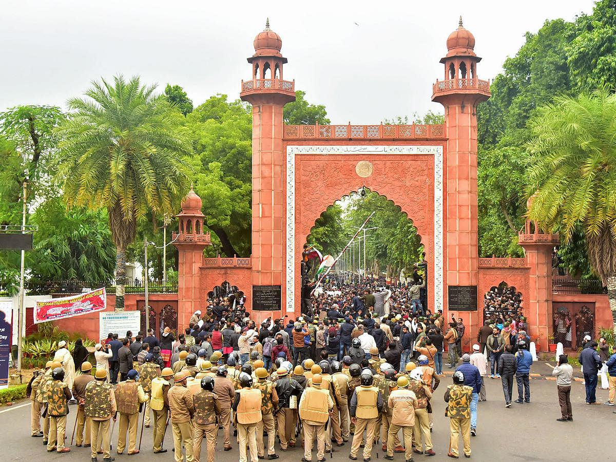 Police personnel stand guard outside Aligarh Muslim University (AMU) as students protest against the passing of Citizenship Amendment Bill. PTI
