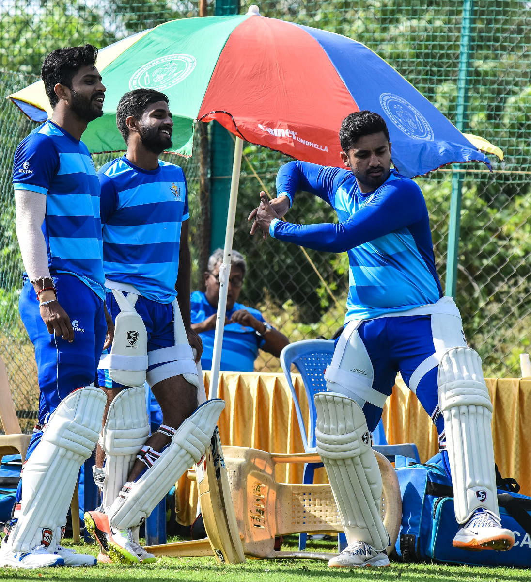 Karnakata stand-in skipper Karun Nair demonstrates a shot as Rohan Kadam (left) and R Samarth look on during a practice session in Hubballi on Monday. DH Photo/ Tazuddin Azad