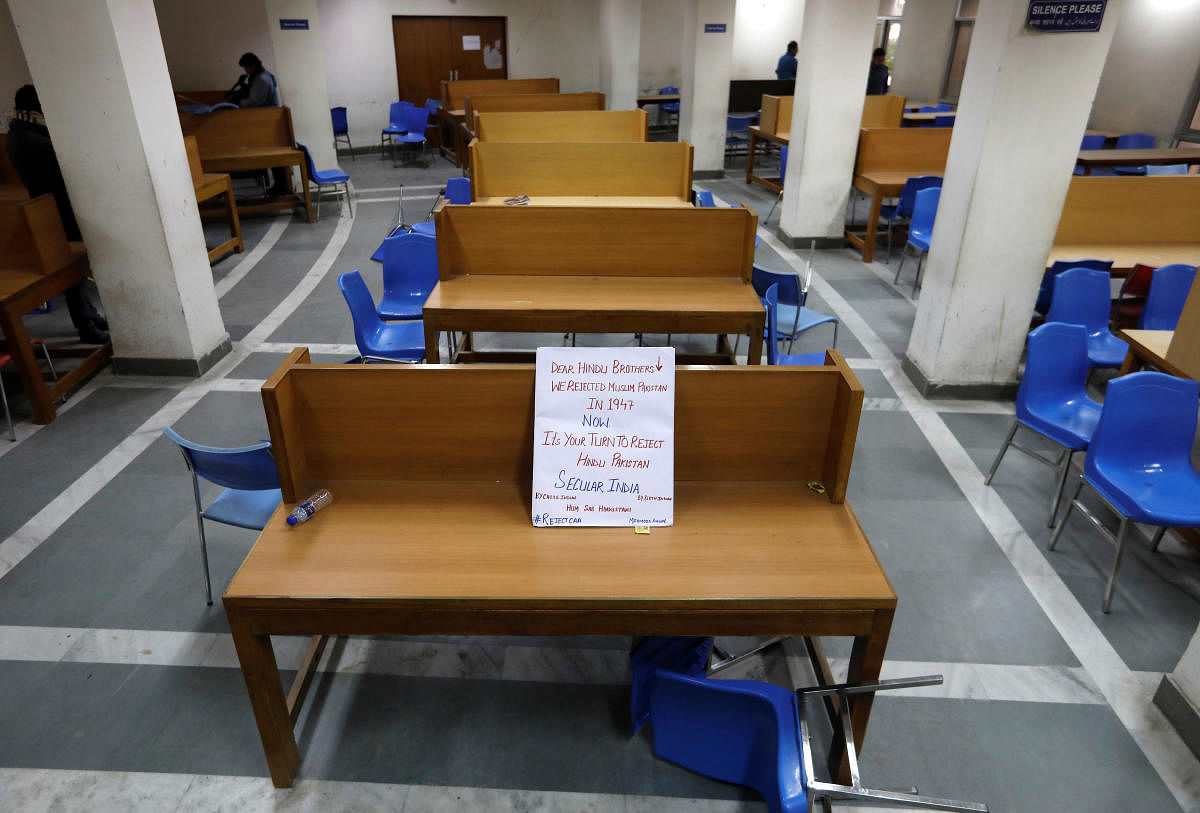 A placard lies on a table inside a partially damaged library of the Jamia Millia Islamia university after police entered the university campus on the previous day, following a protest against a new citizenship law. Reuters