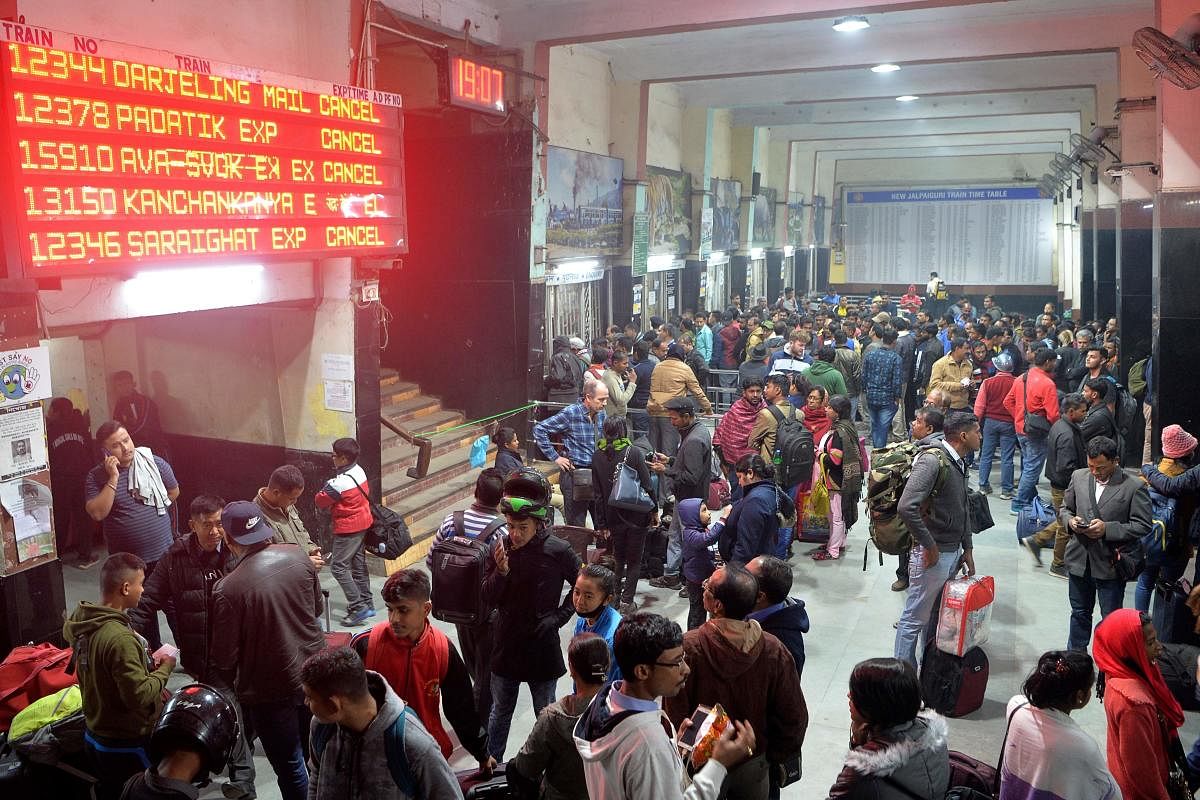 Commuters wait as trains has been cancelled at New Jalpaiguri Railway station on the outskirts of Siliguri. (AFP Photo)