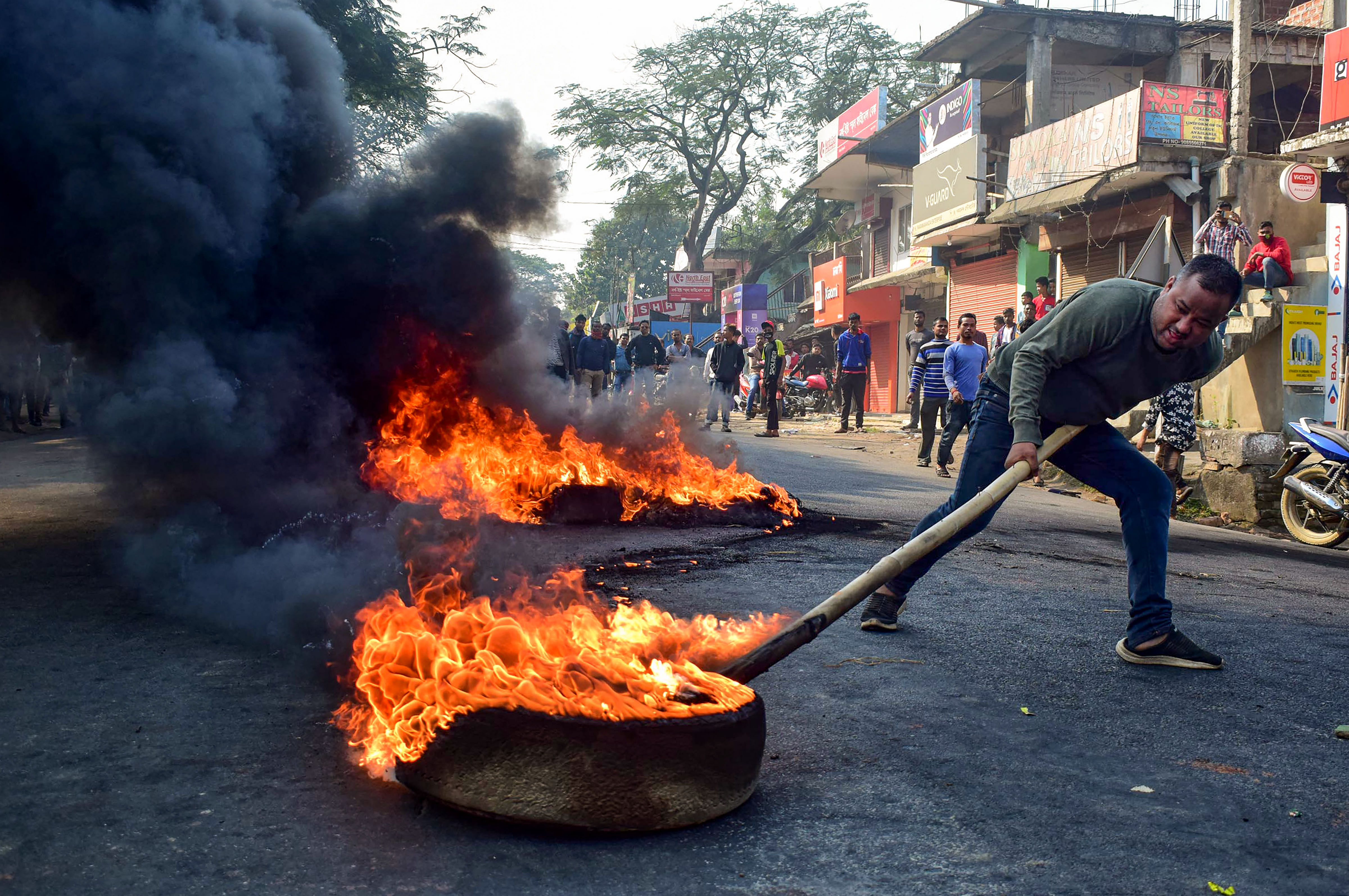 A demonstrator burns tyres on National Highway 17 during a protest rally against CAB, at Boko in Kamrup district of Assam. (PTI Photo)