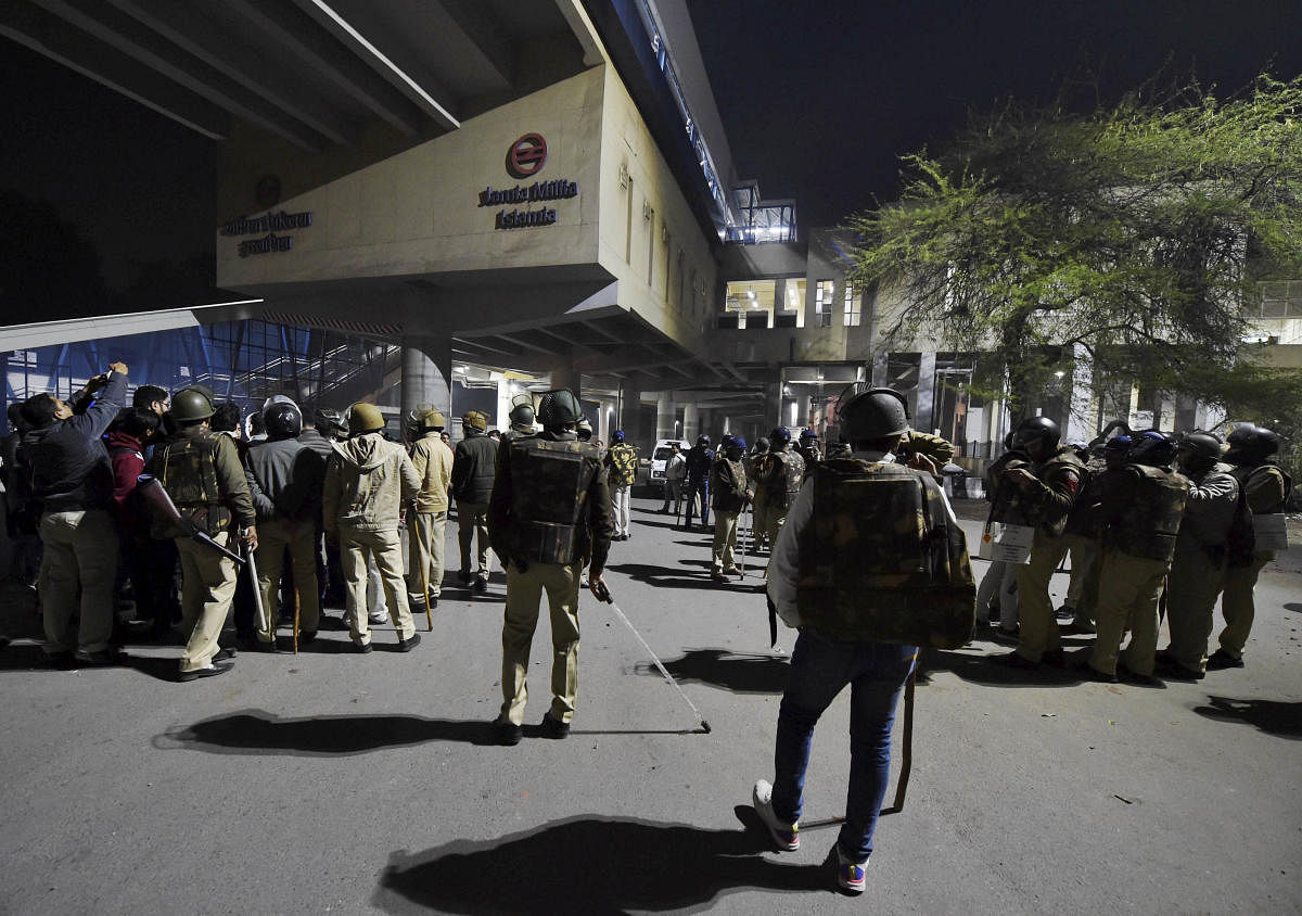 Policemen gather near Jamia Millia Islamia metro station following the protests against Citizenship Amendment Act, in New Delhi, Sunday, Dec. 15, 2019. (PTI Photo/Manvender Vashist)