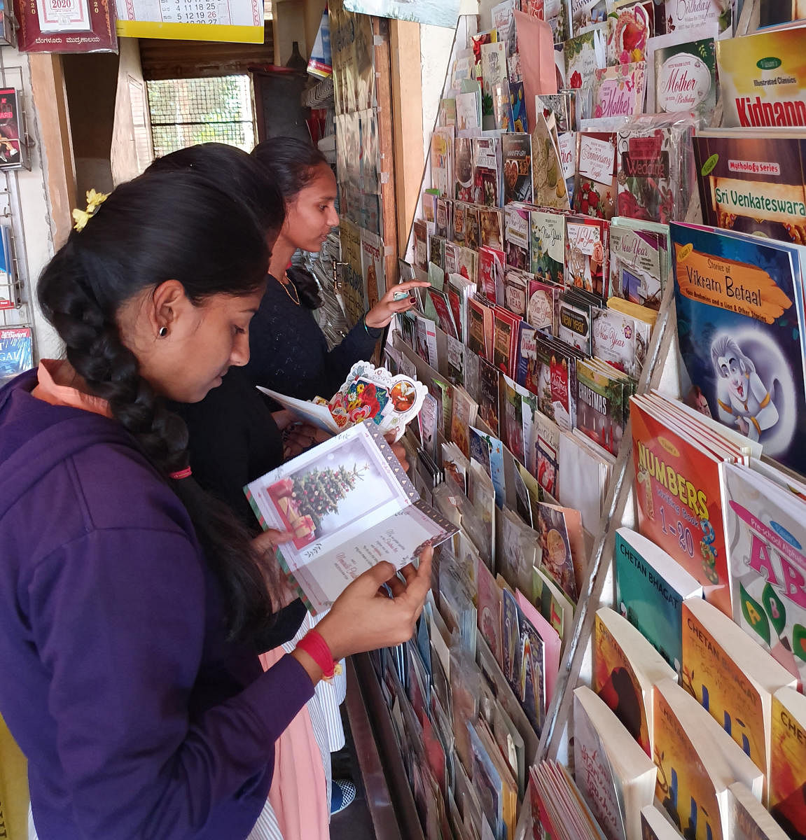 Students engaged in purchasing greeting cards at a book stall on M G Road in Chikkamagaluru.