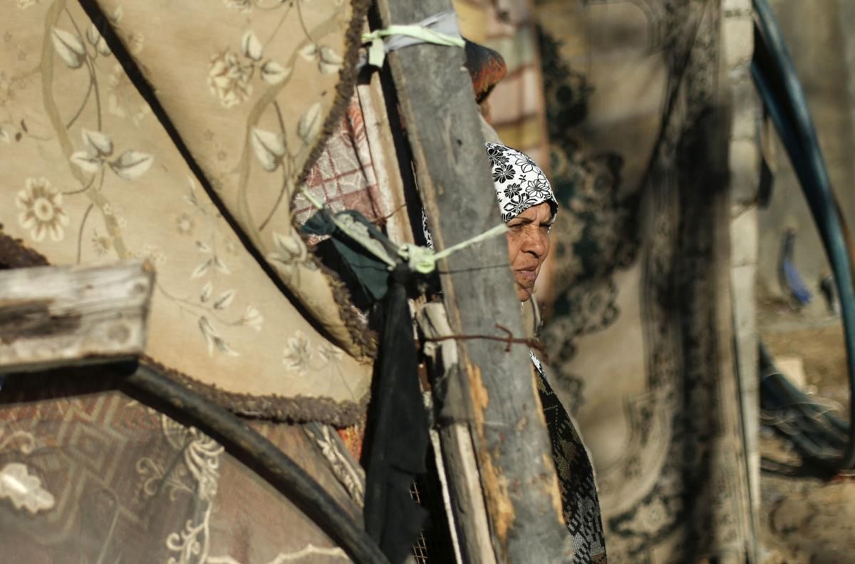 A Palestinian woman stands next her home near the site of an Israeli air strike the previous night in Gaza City on December 19, 2019. Photo/AFP