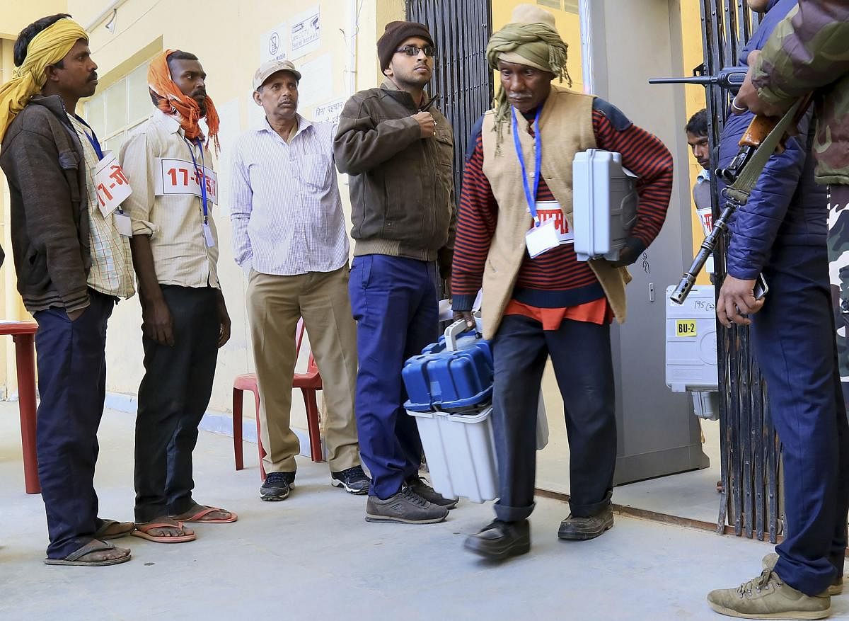 Election polling officials collect EVMs and other polling materials on the eve of the fifth and last phase of Jharkhand Assembly elections. (PTI Photo)