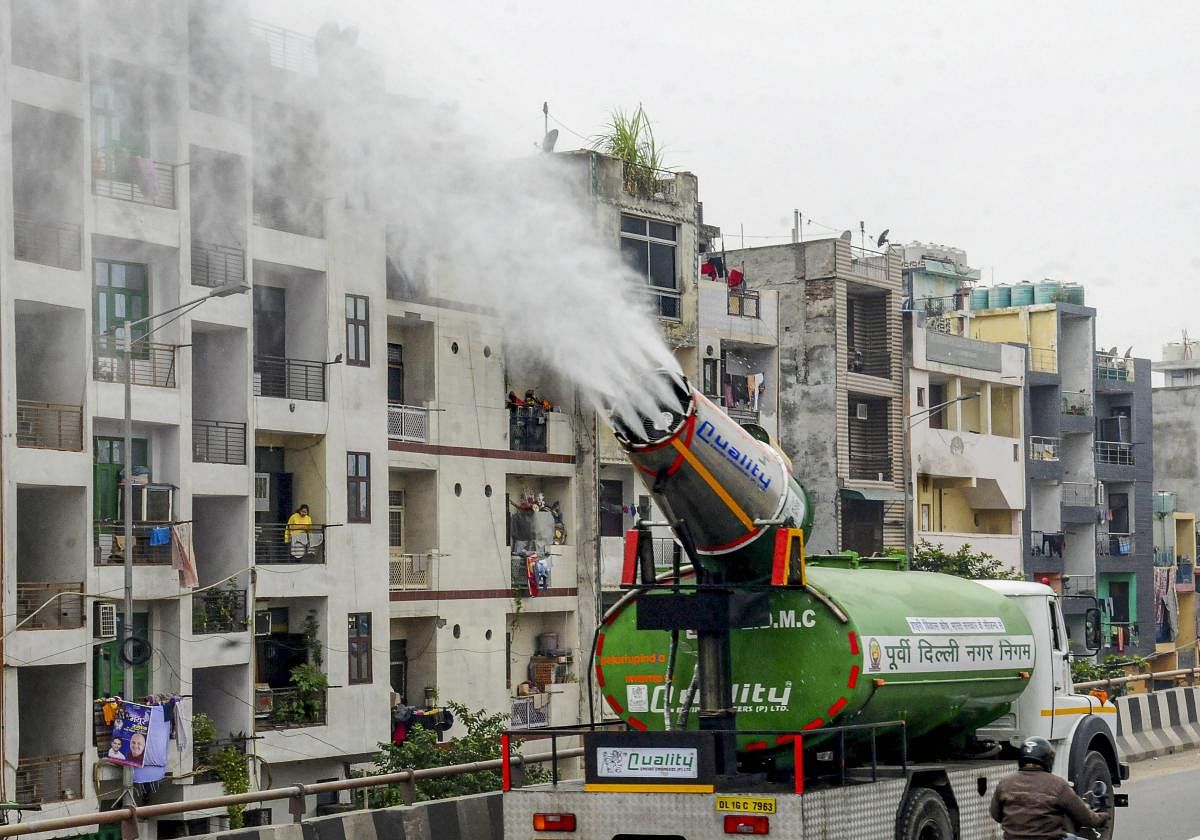 An East Delhi Municipal Corporation (EDMC) water tank with an anti-smog gun sprays water into the air to reduce pollution in New Delhi.