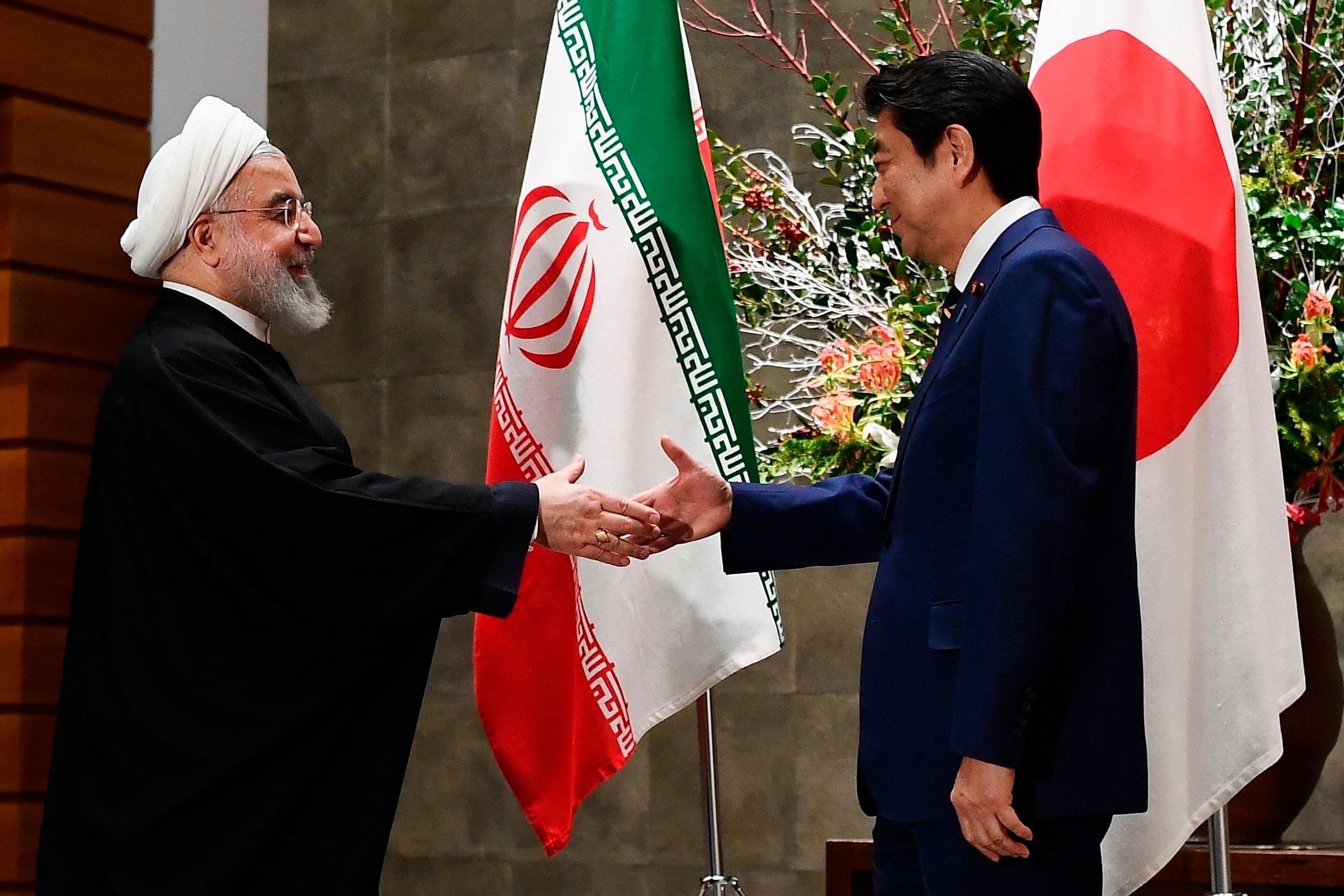 Iranian President Hassan Rouhani, left, and Japanese Prime Minister Shinzo Abe, right, shake hands before their meeting at the prime minister's office in Tokyo. (PTI Photo)