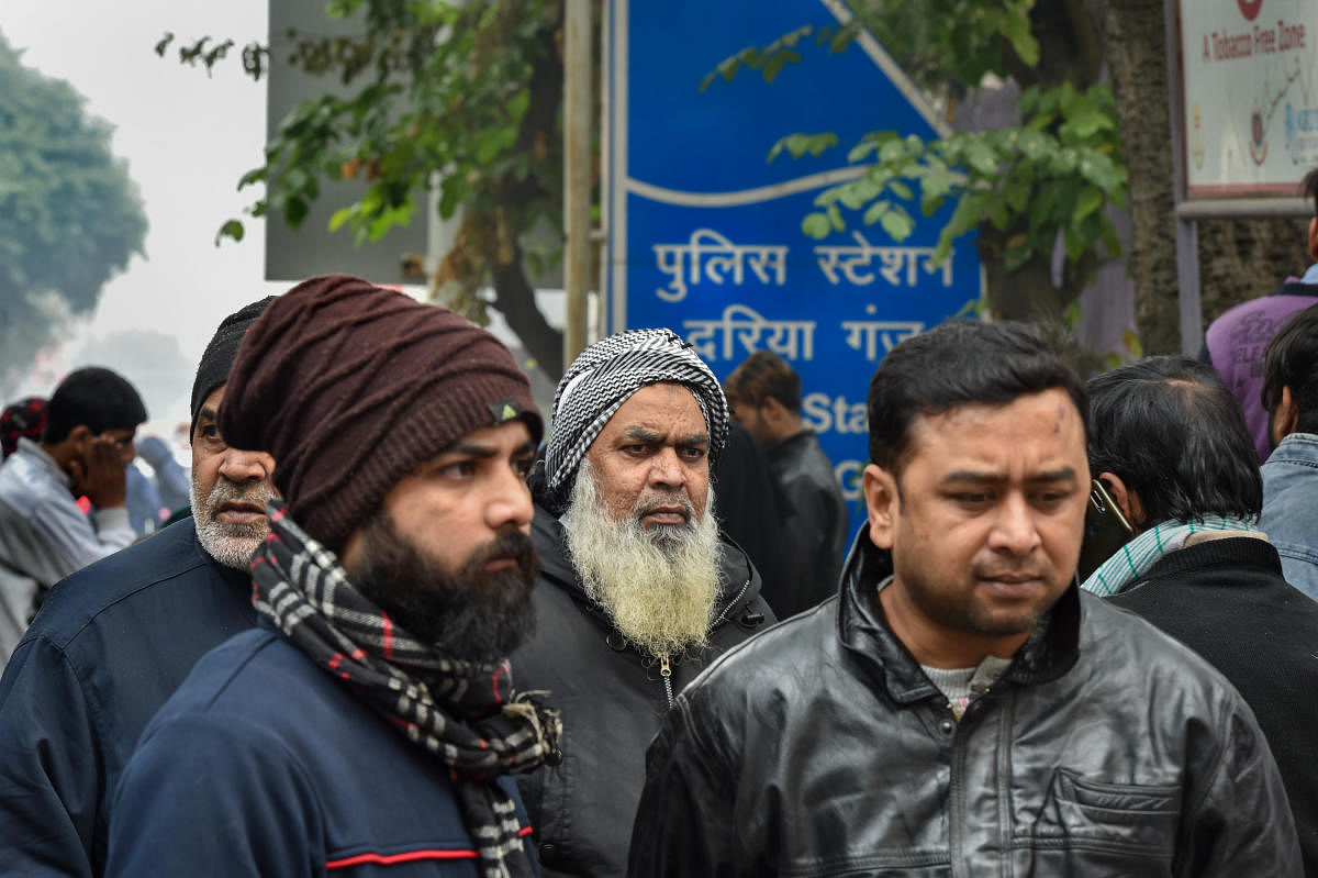 Family members of the people arrested for violence during a rally against the Citizenship Amendment Act (CAA), last evening, wait for their release outside Daryaganj police station, in New Delhi, Saturday, Dec. 21, 2019. (PTI Photo/Manvender Vashist) 