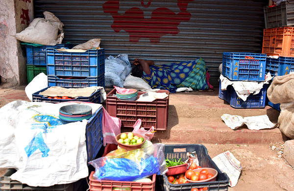In the absence of any business a road-side vendor is forced to seek refuge in a nap near the central market in Mangaluru on Friday. (Photo by GovindraJ Javli)