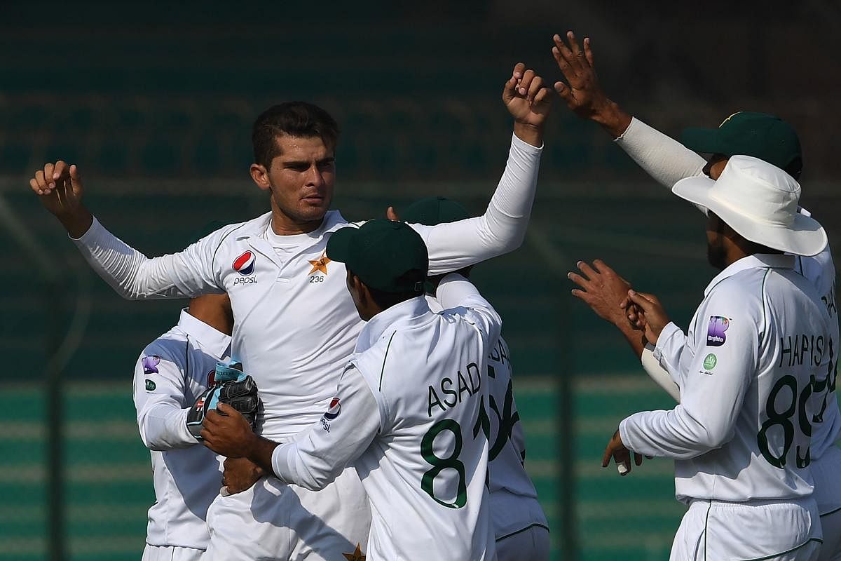 Pakistan's pacer Shaheen Shah Afridi (L) celebrates with teammates after taking the wicket of Sri Lanka's Angelo Mathews during the second day of the second Test cricket match between Pakistan and Sri Lanka at the National Cricket Stadium in Karachi on De